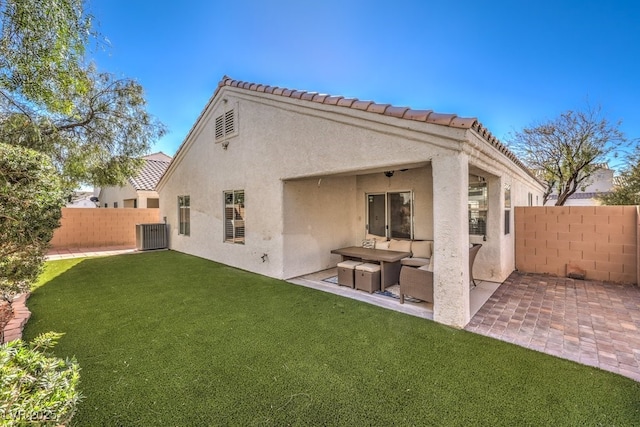 rear view of house with a yard, a patio, stucco siding, an outdoor hangout area, and a fenced backyard