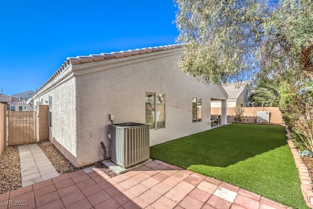 rear view of property with a yard, a patio, cooling unit, and stucco siding