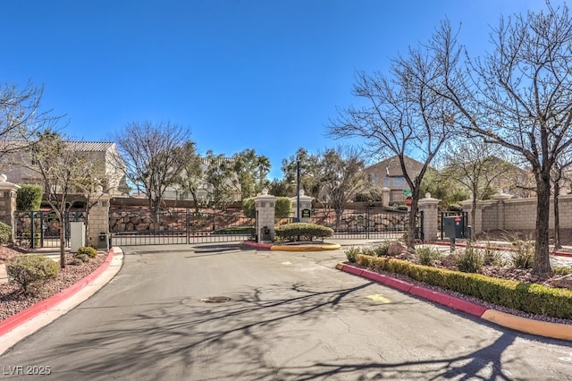 view of road with a gate, a gated entry, and curbs