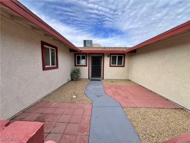 doorway to property featuring a patio and stucco siding