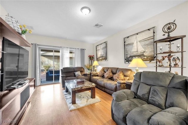 living area with light wood-type flooring and visible vents