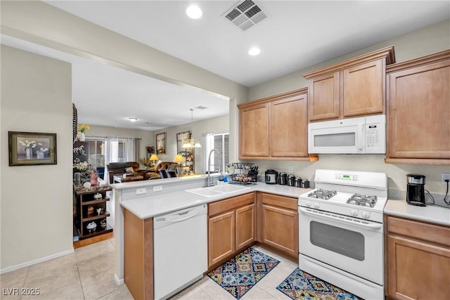 kitchen featuring light countertops, visible vents, open floor plan, a sink, and white appliances