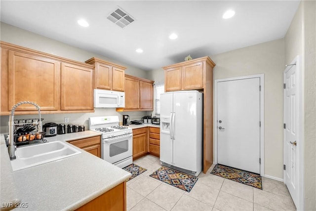 kitchen featuring white appliances, visible vents, light countertops, a sink, and recessed lighting