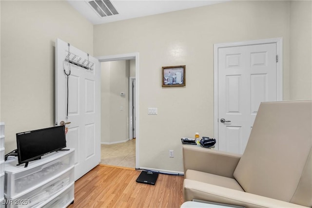 office space with wood finished floors, visible vents, and baseboards