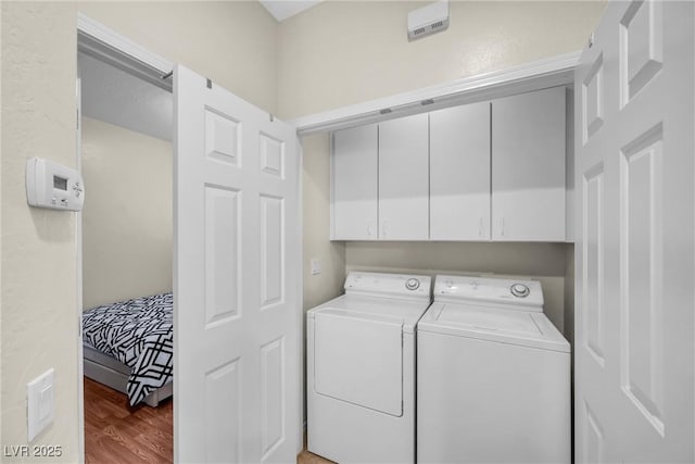 clothes washing area with cabinet space, independent washer and dryer, and wood finished floors