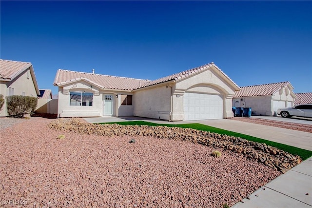 mediterranean / spanish-style home with a garage, stucco siding, concrete driveway, and a tiled roof