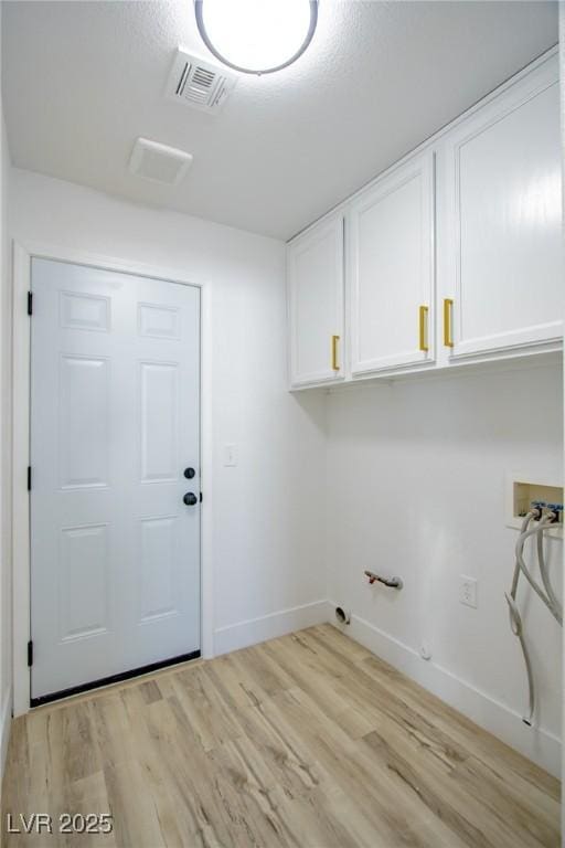 laundry room featuring visible vents, light wood-style flooring, gas dryer hookup, and cabinet space