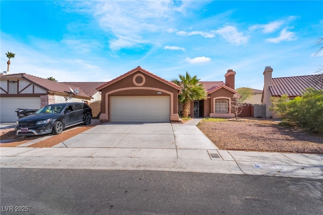 view of front of property featuring a garage, concrete driveway, a tile roof, and stucco siding