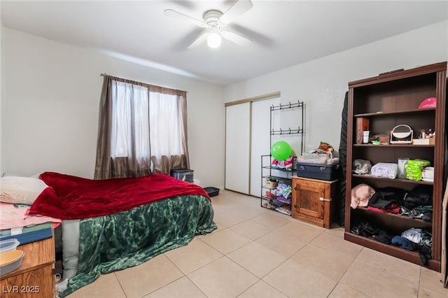 bedroom featuring a ceiling fan, a closet, and light tile patterned floors