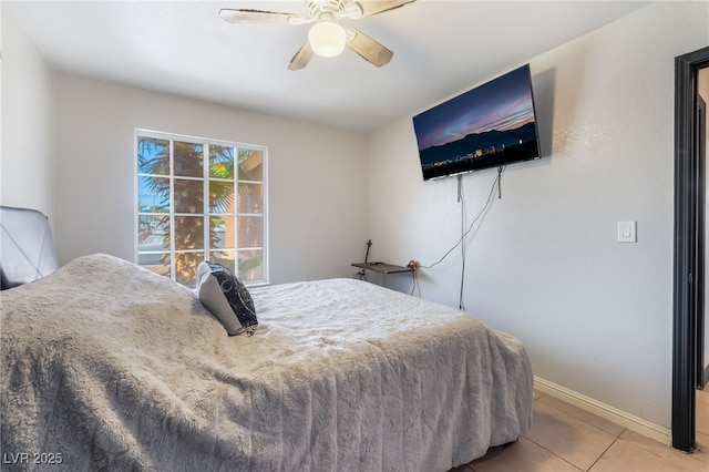 bedroom with ceiling fan, baseboards, and light tile patterned floors