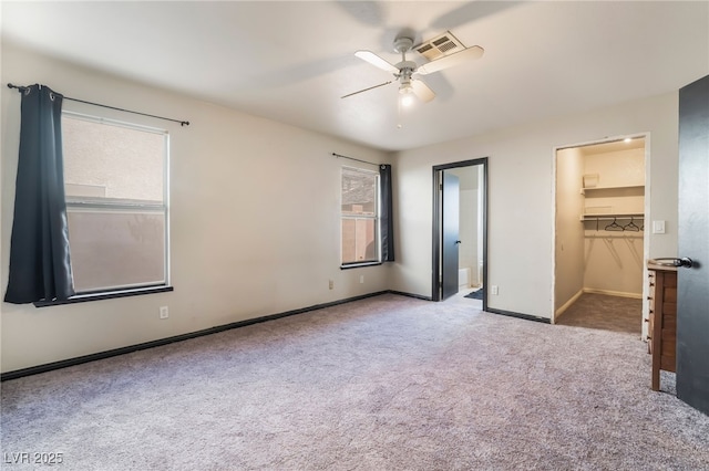 unfurnished bedroom featuring a spacious closet, carpet flooring, visible vents, and multiple windows