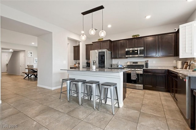 kitchen with a center island, dark brown cabinetry, a kitchen breakfast bar, stainless steel appliances, and a sink