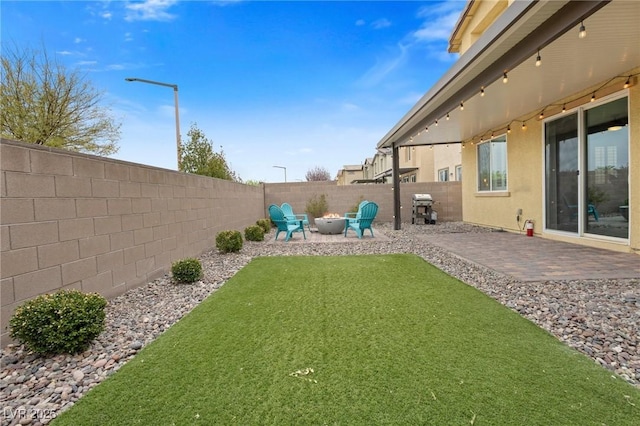 view of yard with a patio, a fire pit, and a fenced backyard