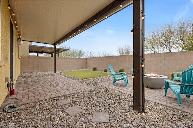 view of patio featuring an outdoor fire pit and a fenced backyard