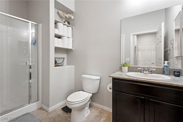 full bath with a shower stall, toilet, vanity, and baseboards