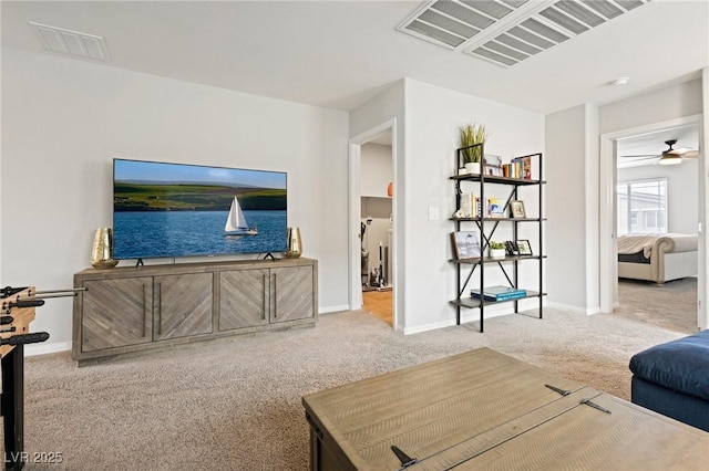 carpeted living area with visible vents, ceiling fan, and baseboards