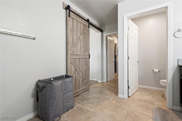 bathroom with toilet and baseboards