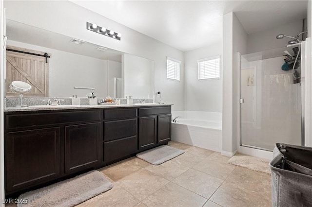 bathroom with double vanity, a shower stall, a garden tub, and a sink