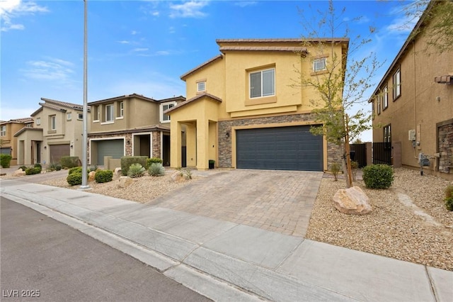 view of front facade with stucco siding, decorative driveway, stone siding, fence, and an attached garage