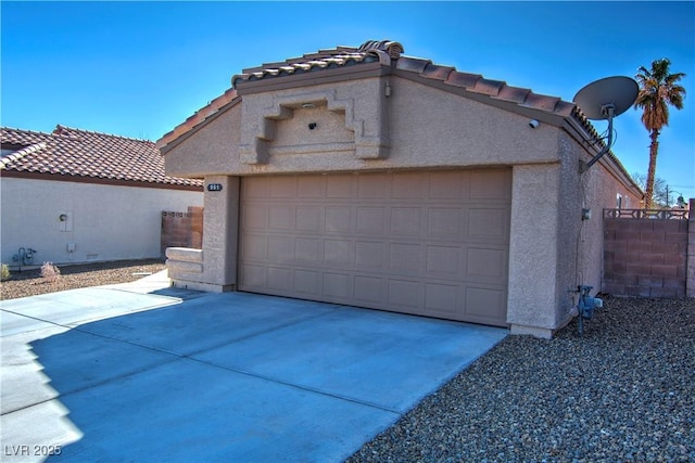 view of front of house with an outbuilding, driveway, a tiled roof, and stucco siding