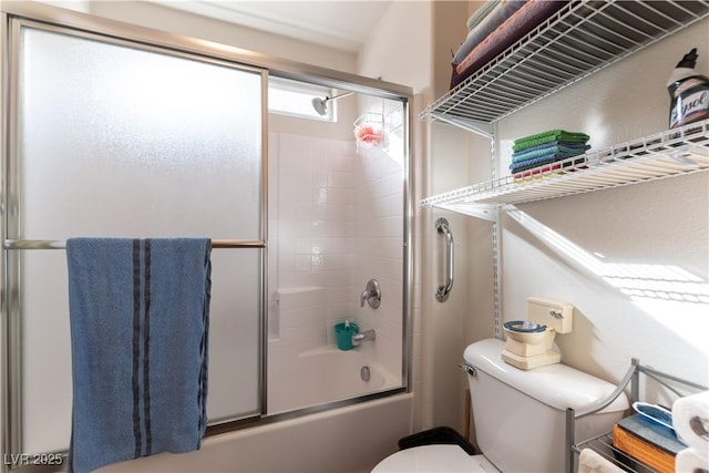 full bath featuring toilet and combined bath / shower with glass door