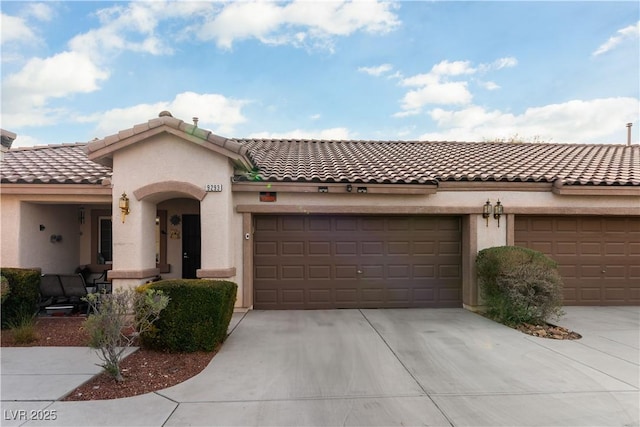 mediterranean / spanish-style house with driveway, an attached garage, and stucco siding