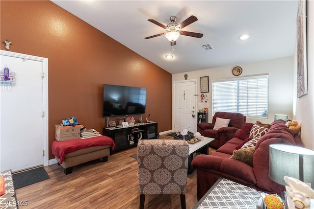 living area with a ceiling fan, baseboards, vaulted ceiling, visible vents, and light wood-style floors