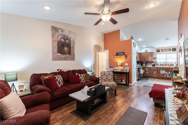 living area with recessed lighting, wood finished floors, visible vents, a ceiling fan, and vaulted ceiling