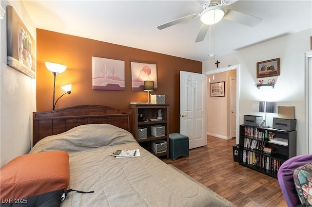 bedroom featuring ceiling fan, baseboards, and wood finished floors