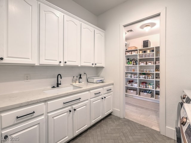 interior space with independent washer and dryer, a sink, and visible vents