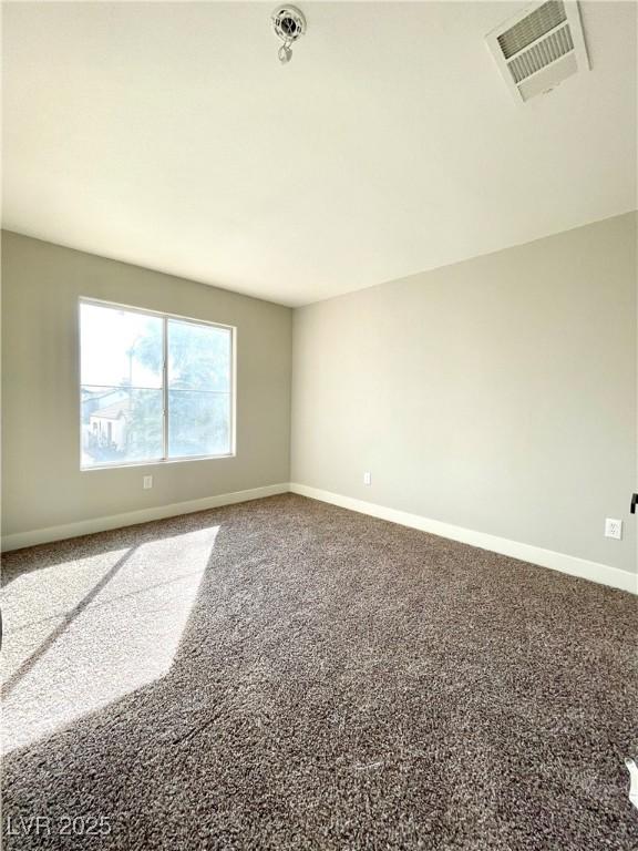 carpeted empty room featuring visible vents and baseboards