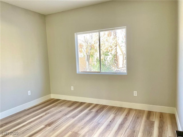 empty room featuring light wood-style flooring and baseboards