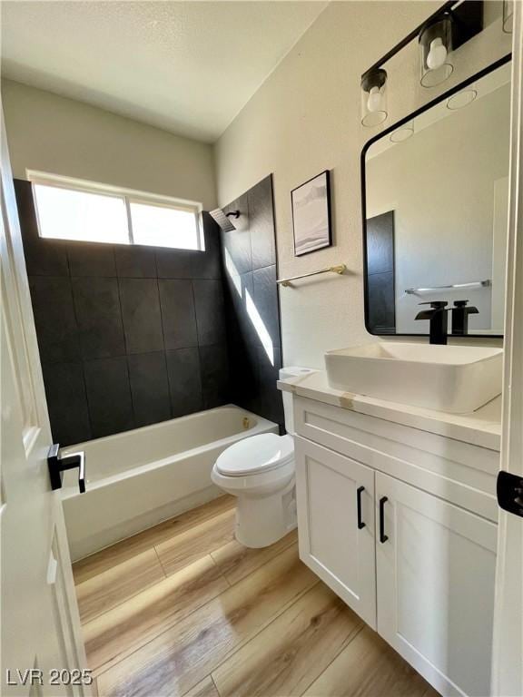 full bathroom with toilet, shower / tub combination, wood finished floors, and vanity