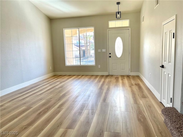 entryway featuring baseboards, visible vents, and light wood finished floors