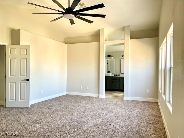 unfurnished bedroom with baseboards, vaulted ceiling, connected bathroom, and light colored carpet