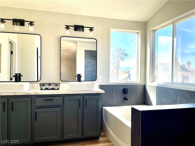 bathroom featuring a healthy amount of sunlight, double vanity, and a sink