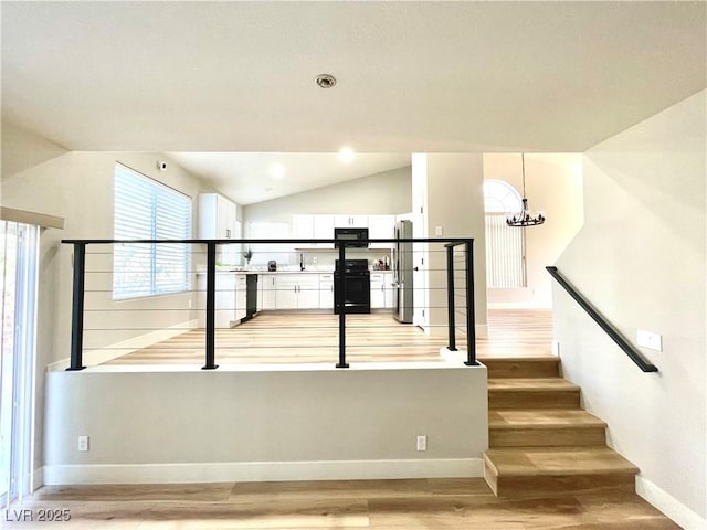 staircase featuring baseboards, lofted ceiling, wood finished floors, a notable chandelier, and recessed lighting