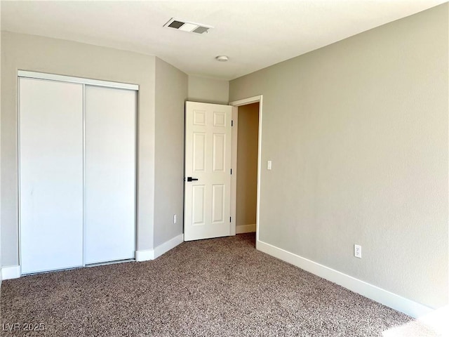 unfurnished bedroom featuring a closet, carpet flooring, visible vents, and baseboards