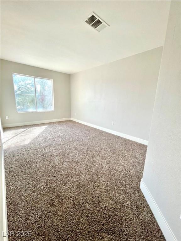 carpeted empty room featuring visible vents and baseboards