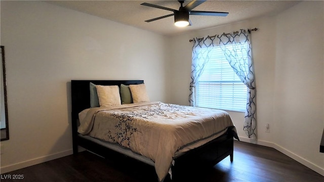 bedroom featuring dark wood-style floors, multiple windows, and baseboards