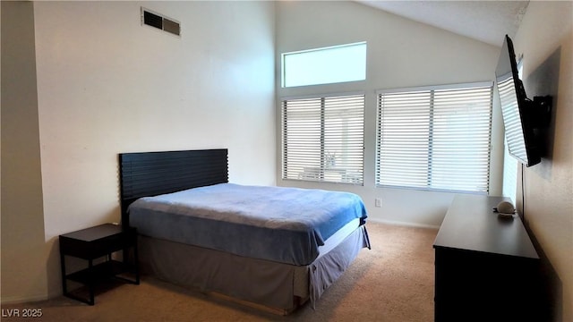 bedroom with lofted ceiling, visible vents, and light colored carpet