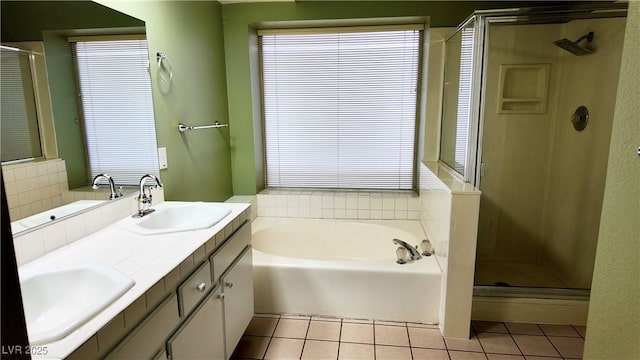 bathroom with a garden tub, tile patterned flooring, a sink, and a stall shower