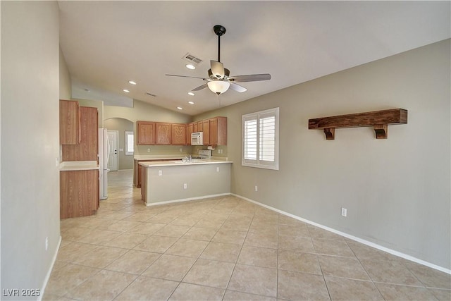 kitchen featuring arched walkways, visible vents, light countertops, white appliances, and a peninsula