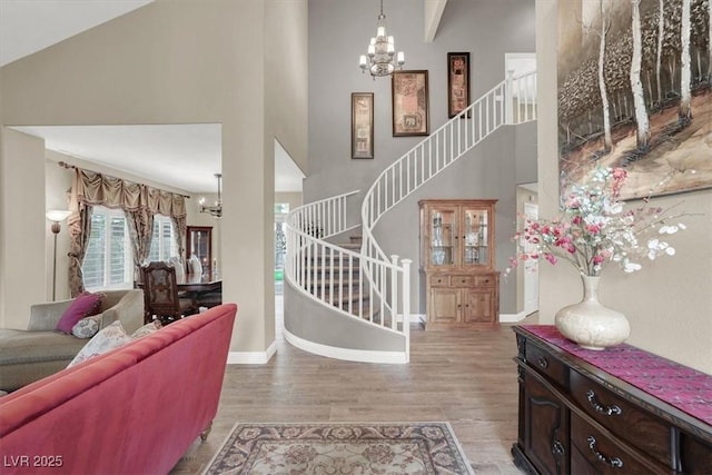 foyer with a chandelier, stairs, and light wood-style flooring