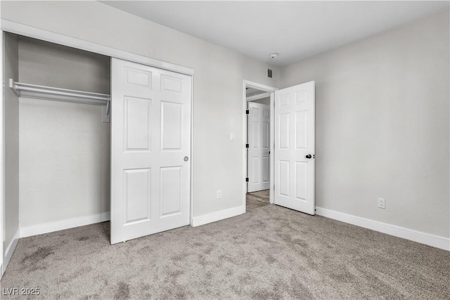 unfurnished bedroom featuring a closet, light colored carpet, visible vents, and baseboards