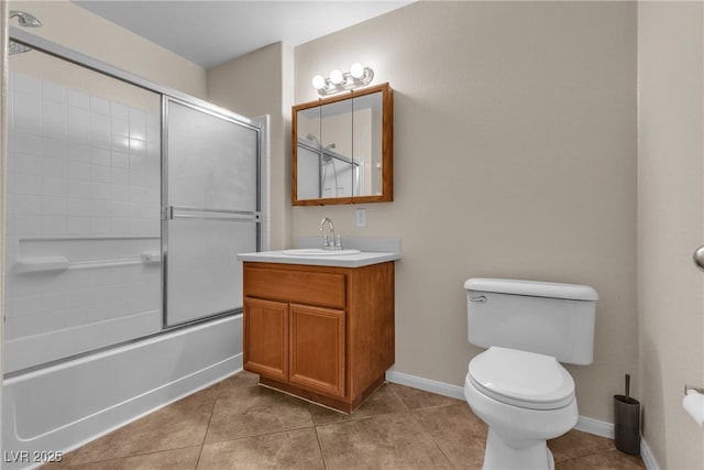 full bathroom with baseboards, toilet, shower / bath combination with glass door, tile patterned floors, and vanity