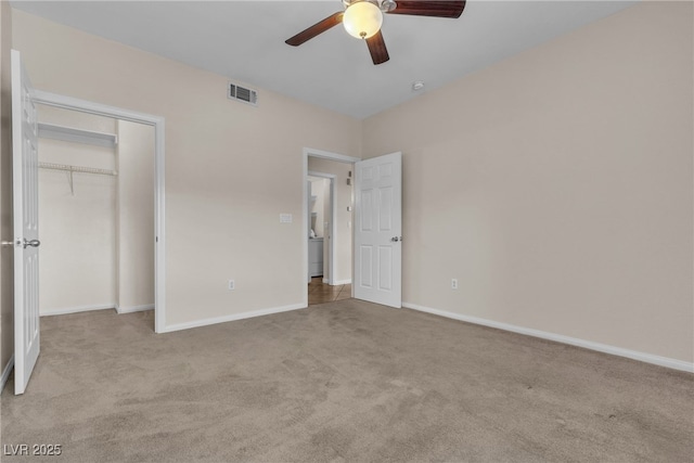 unfurnished bedroom with ceiling fan, light colored carpet, visible vents, baseboards, and a closet