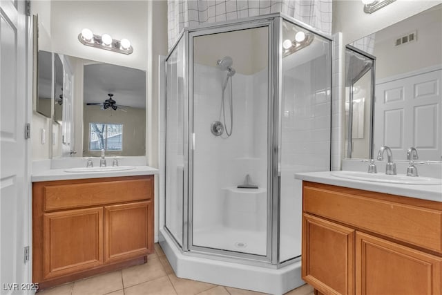 full bathroom featuring a ceiling fan, a sink, a shower stall, and tile patterned floors