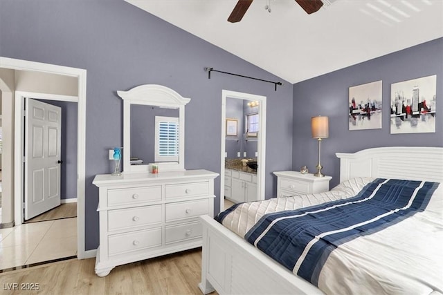 bedroom featuring light wood finished floors, connected bathroom, vaulted ceiling, ceiling fan, and baseboards