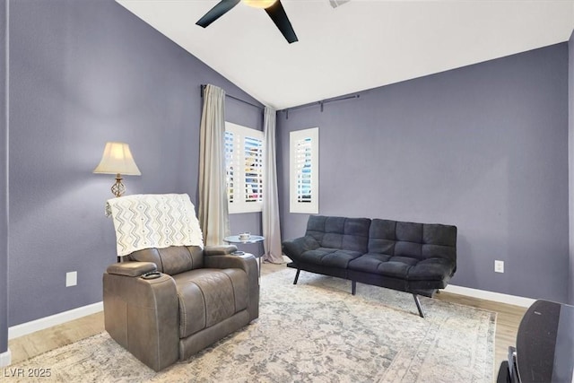 living area with lofted ceiling, wood finished floors, a ceiling fan, and baseboards